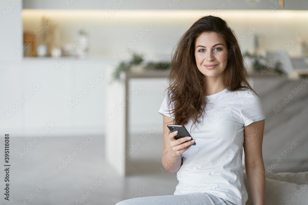 Fototapeta premium The brunette woman smiles. Phone training at home. portrait a foreign language teacher conducts a lesson remotely online conference with students via a video communication app.