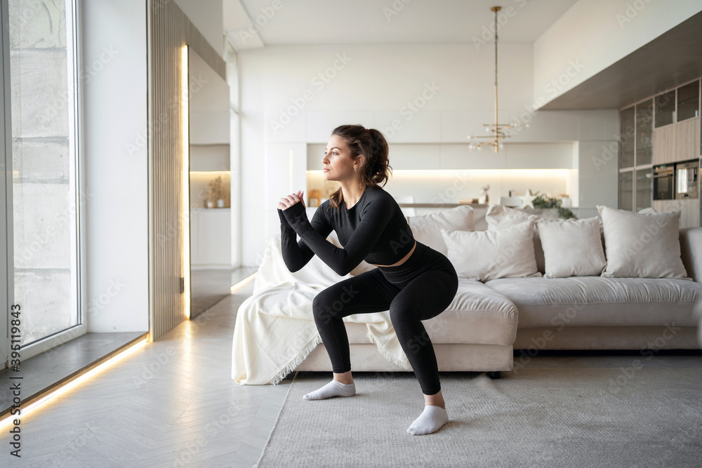 Fitness is a sport to promote health and a strong body. a woman of European appearance. training exercises stretching in front of a laptop computer online trainer at home.