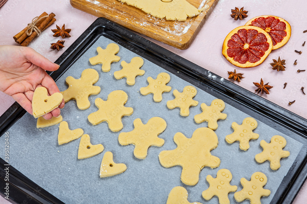 Christmas traditional bakery. Family cooking process making gingerbread and hearts cookies. Cookies on baking paper are ready for baking. Christmas traditional bakery. Family cooking process making gingerbread and hearts cookies. Cookies on baking paper are ready for baking.