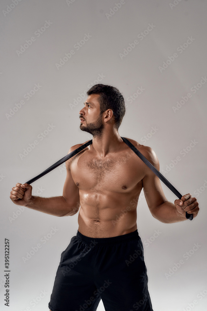Young shirtless caucasian sportsman with elastic rubber Young shirtless caucasian sportsman with elastic rubber
