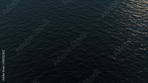 Calm waves in the sea aerial view with sun reflection