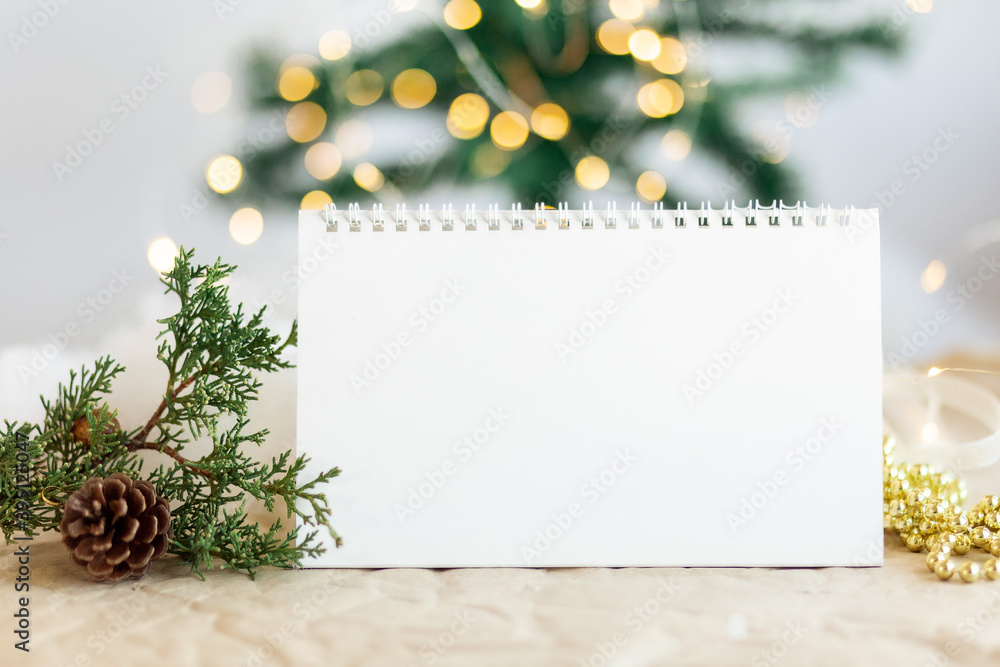 Mock up, copy space. Blank spiral calendar with sparkling gold bokeh on New tree background, fir branch and xmas toys. Mock up, copy space. Blank spiral calendar with sparkling gold bokeh on New tree background, fir branch and xmas toys.
