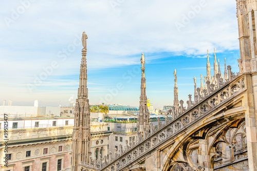 Roof of Milan Cathedral Duomo di Milano with Gothic spires and white marble statues. Top tourist attraction on piazza in Milan, Lombardia, Italy. Wide angle view of old Gothic architecture and art. © Юлия Завалишина