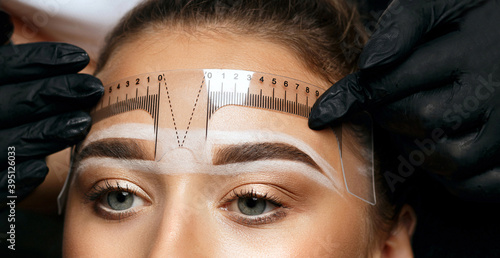 Measuring of eyebrows with ruler before permanent makeup photo