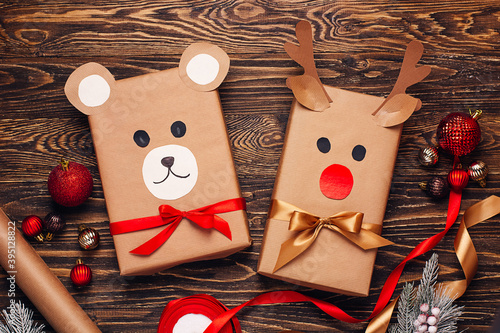Creatively wrapped Christmas gifts in the shape of a teddy bear and a deer. New Year and Christmas concept. DIY gift wrapping. Preparation for holidays. Top view, close up