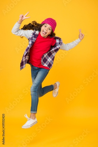 energetic kid fashion. child having long curly hair. autumn trendy look. childhood happiness. concept of female beauty. sincere emotions. freedom. happy teen girl casual style running. back to school
