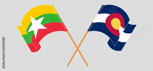 Crossed and waving flags of Myanmar and The State of Colorado
