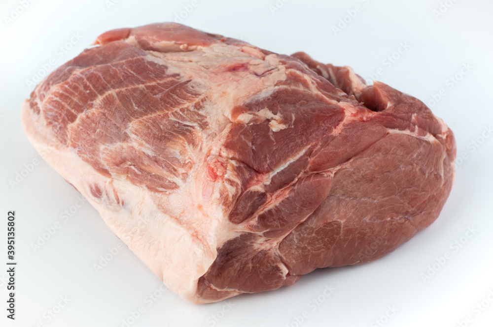 A piece of raw pork meat lies on a white background. A piece of raw pork meat lies on a white background.