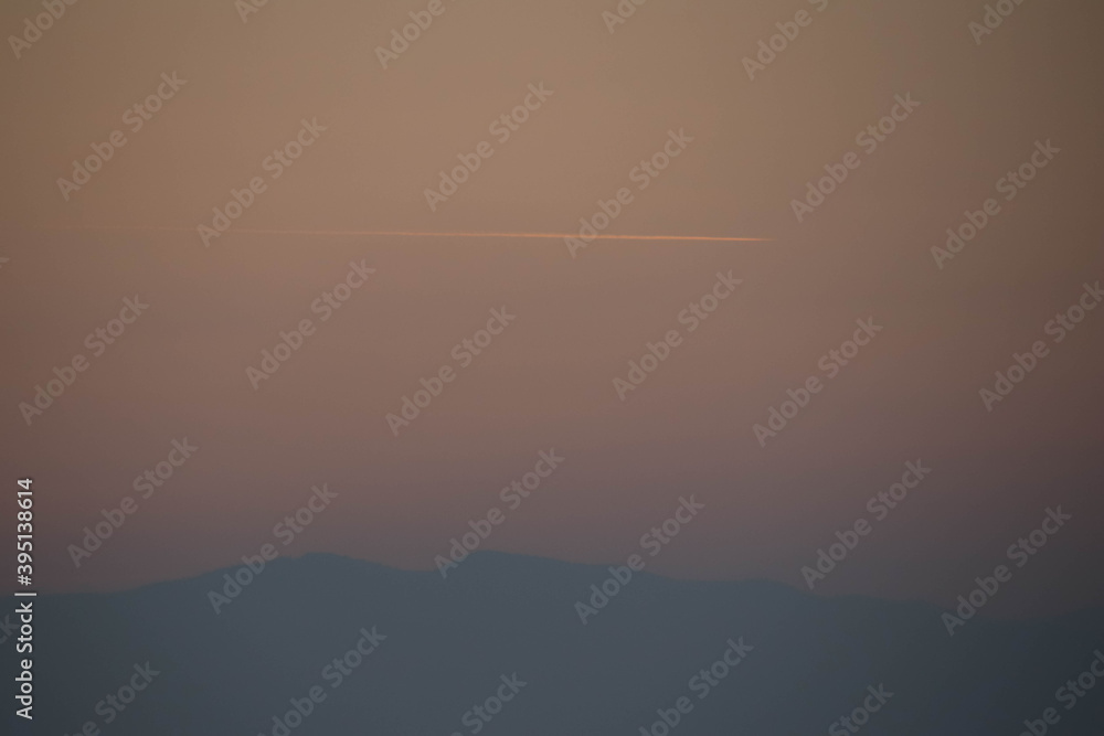 Close up of a airplane trance and hill on orange sky.
