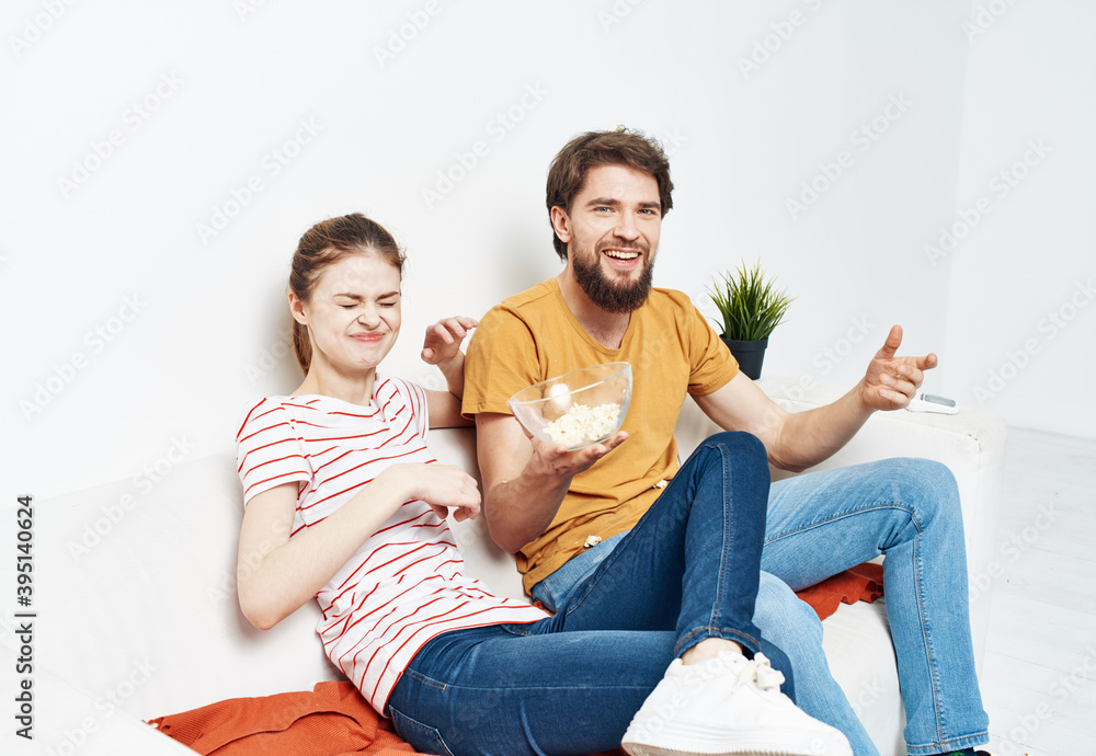 Man eating popcorn and pretty woman in a bright room family friends communicatio Man eating popcorn and pretty woman in a bright room family friends communicatio