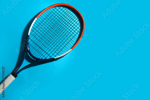 Tennis racket on blue background, top view. Space for text