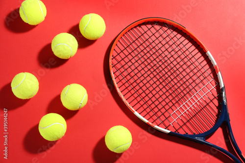 Tennis racket and balls on red background, flat lay. Sports equipment © New Africa