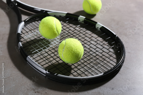 Tennis racket and balls on grey table. Sports equipment © New Africa
