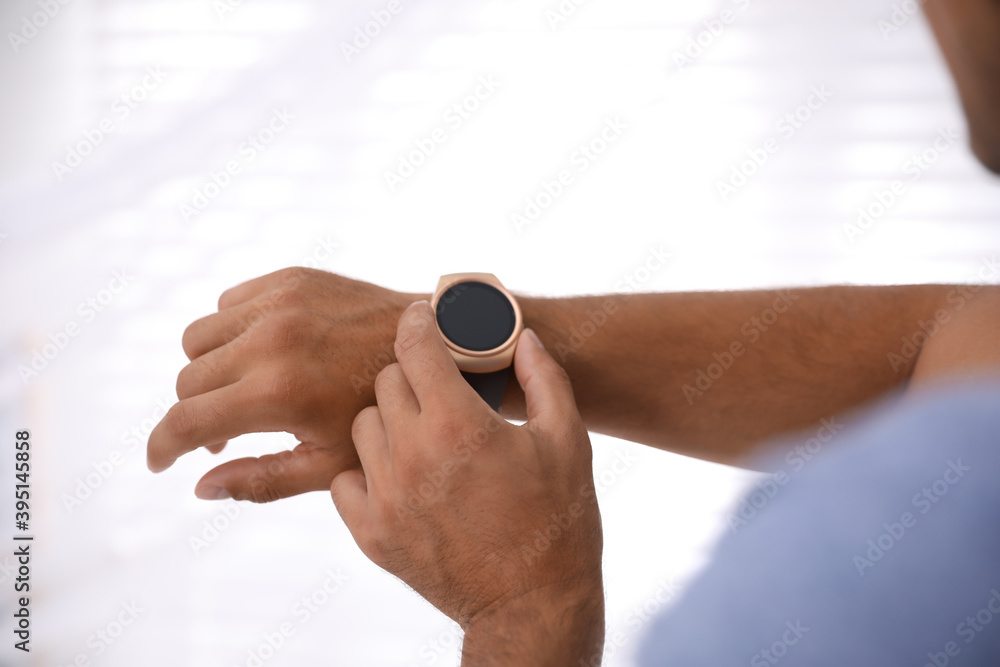 Fototapeta premium Man with smart watch on light background, closeup