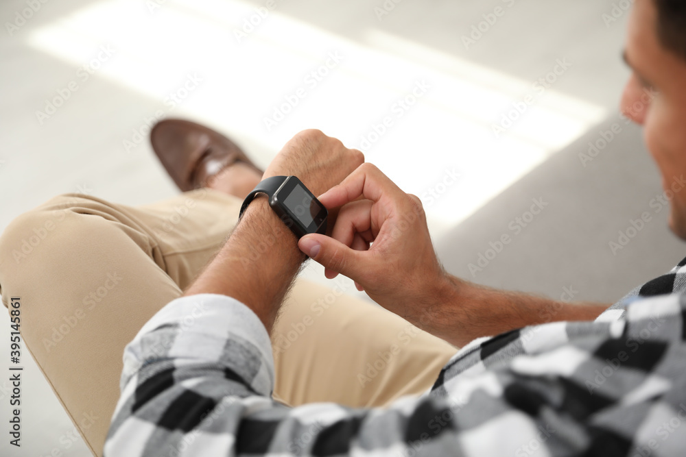 Man with smart watch on blurred background, closeup