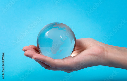 Glass model of the globe on a human hand