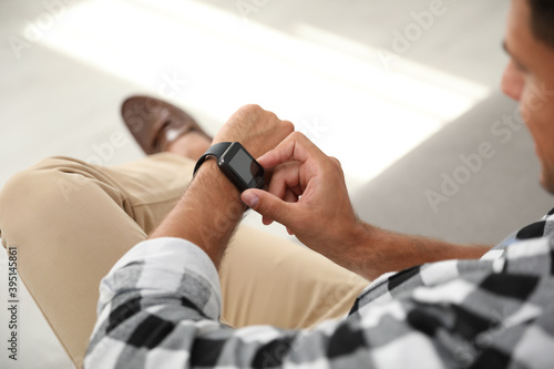 Man with smart watch on blurred background, closeup