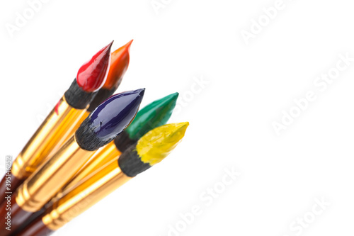 Brushes with colorful paints on white background