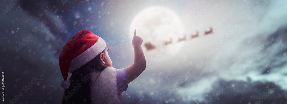 little girl surprised to see Santa Claus on beautiful Christmas night under moonlight little girl surprised to see Santa Claus on beautiful Christmas night under moonlight