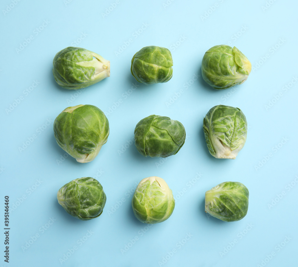 Fototapeta premium Fresh Brussels sprouts on light blue background, flat lay