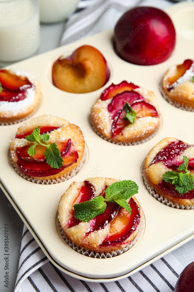 Delicious cupcakes with plums in baking pan Delicious cupcakes with plums in baking pan