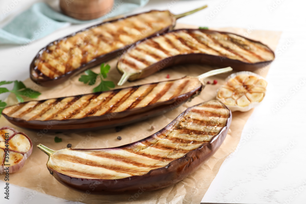 Delicious grilled eggplant halves on white wooden table, closeup Delicious grilled eggplant halves on white wooden table, closeup