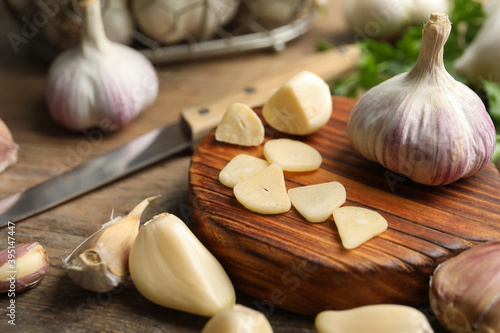 Fresh sliced and whole garlic on wooden table, closeup. Organic product