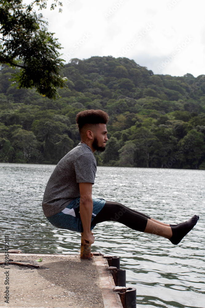 Fototapeta premium young man stretching on the shore of a lake