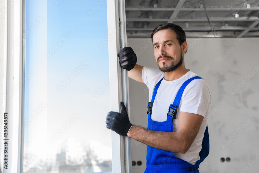 Bearded craftsman checks the plastic window in the apartment Bearded craftsman checks the plastic window in the apartment