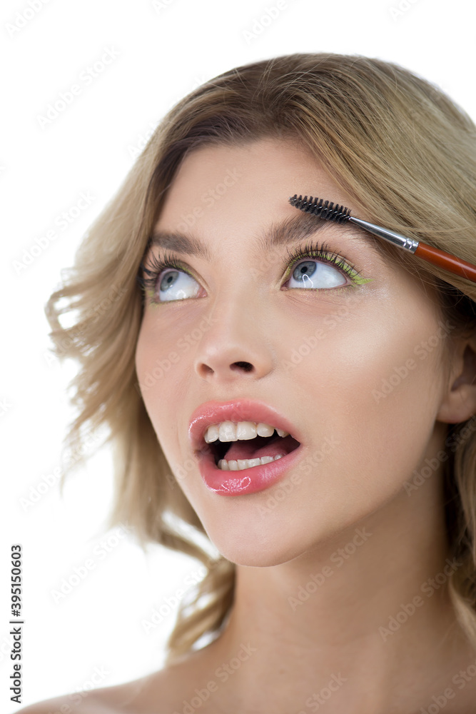Beautiful young woman with clean perfect skin shapes her brow. Beautiful young woman with clean perfect skin shapes her brow.