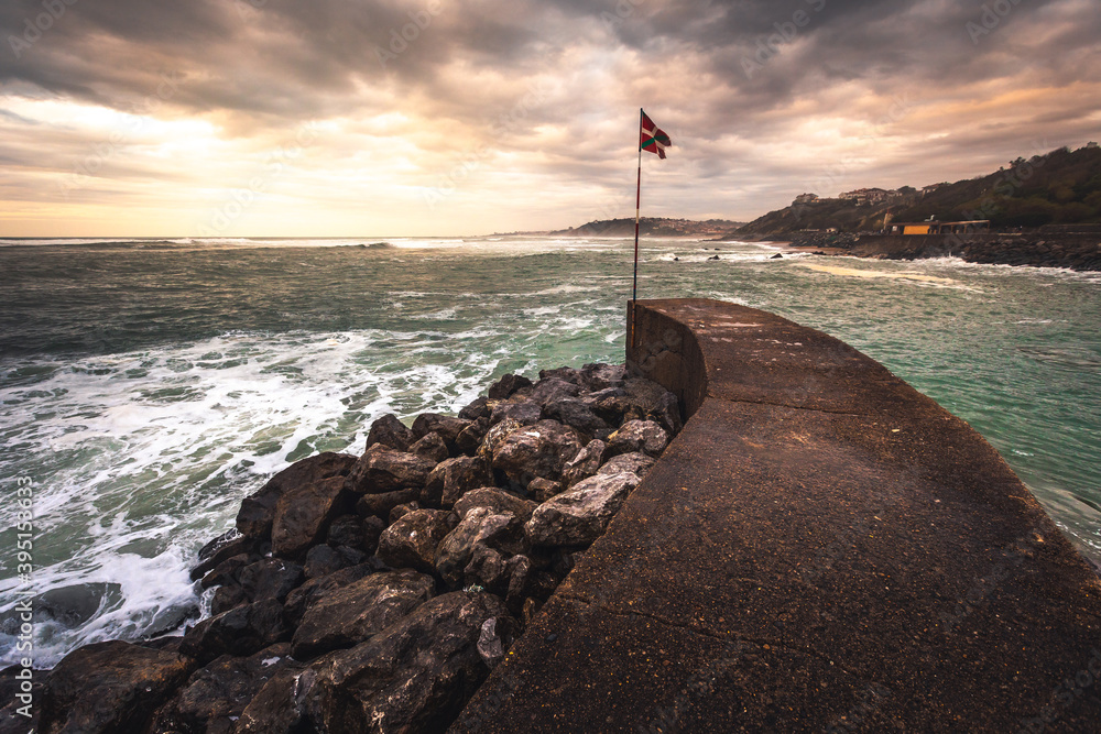 Basque national flag (Ikurriña) at the edge of a pier on the coast; Getaria, North Basque Country.