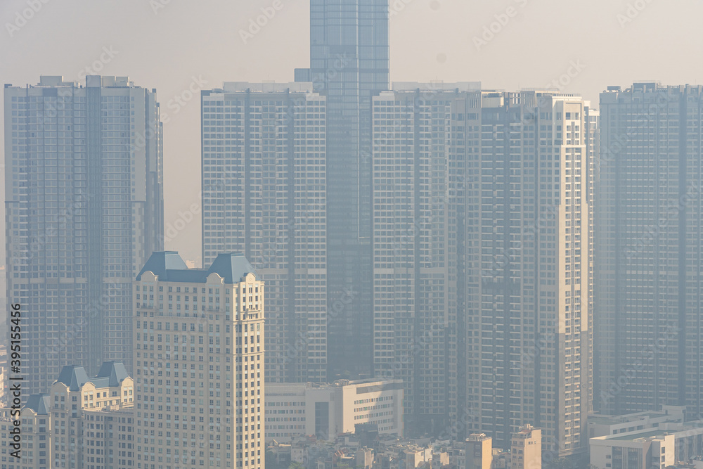 Tall buildings in industrial city with hazy polluted smog 