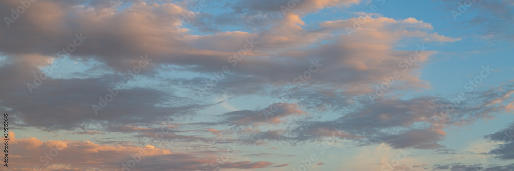 Beautiful sunset sky background with clouds. Scenic cloudscape. Wide panoramic background for design.