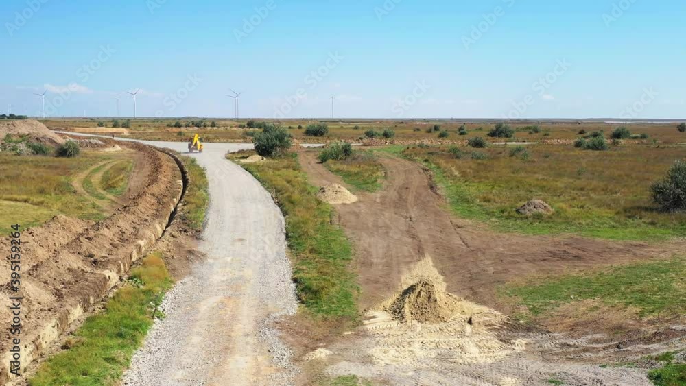 Excavator is driving on a country road on a sunny day, landscape, 4k Excavator is driving on a country road on a sunny day, landscape, 4k