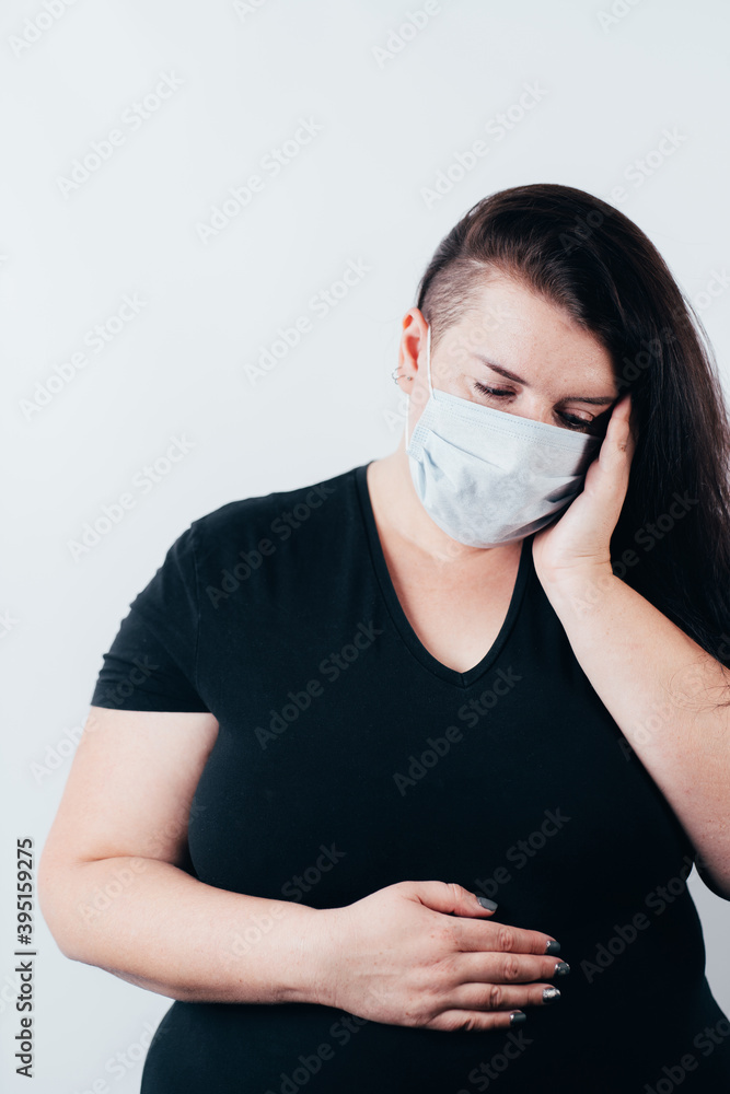 Woman in mask suffering from headache and pain
