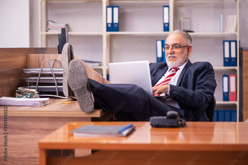 Old male employee sitting in the office Old male employee sitting in the office