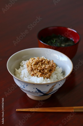 Obraz na płótnie A close up shot of some finely chopped fermented soybeans on freshly cooked white rice in a ceramic rice bowl. w salonie
