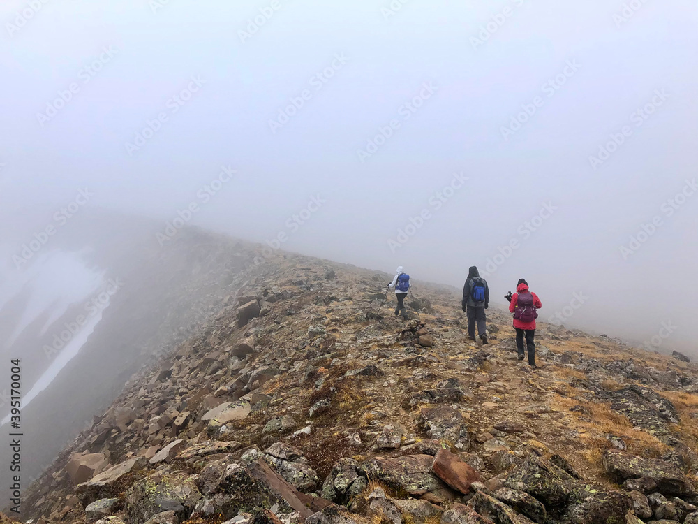 Group of people walking on the ridge on foggy weather. Cathedral Provincial Park. Ocanagan. Keremeos. British Columbia. Canada  