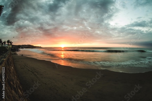 sunset on the horizon with waves crashing on Mancora beach