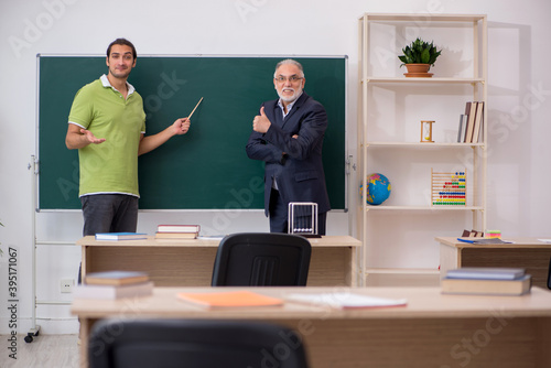 Aged teacher and male student in the classroom