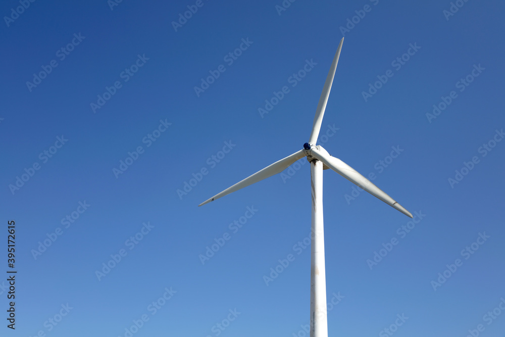 Close-up of electric windmill under clear blue sky