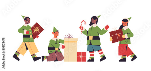 green elves in costumes preparing gifts mix race boys girls santa helpers happy new year merry christmas holidays celebration concept full length horizontal vector illustration