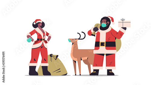 african american man woman in masks wearing santa claus costumes happy new year merry christmas holiday celebration concept full length horizontal vector illustration