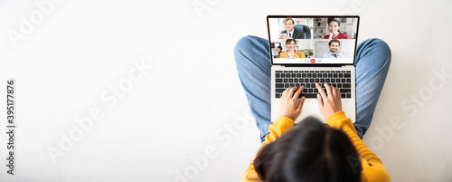 Top view of woman sitting on floor and using laptop video call conference her team. Panoramic image with empty copy space