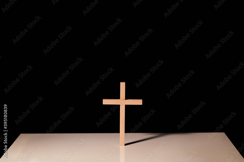 Cross illuminated in the night on a simple altar