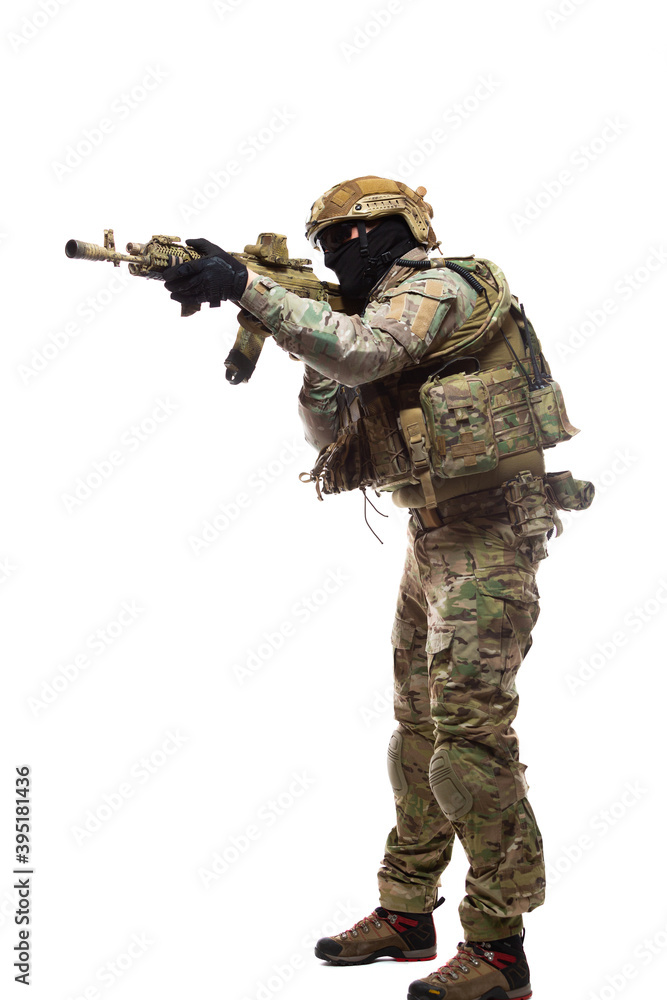 Full length portrait of soldier in combat ammunition in hard hat and glasses with a weapon equipped with collimator sight is aiming at the enemy ready to shoot to kill isolated on white background Full length portrait of soldier in combat ammunition in hard hat and glasses with a weapon equipped with collimator sight is aiming at the enemy ready to shoot to kill isolated on white background