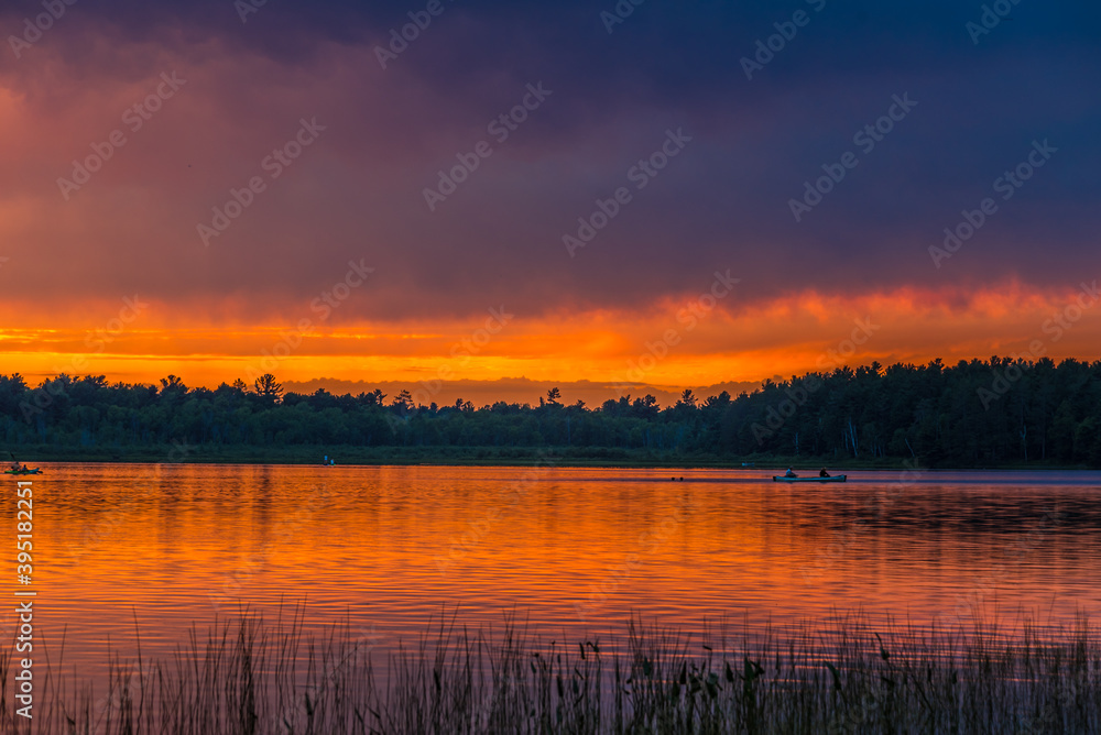 Sunset above forest lake