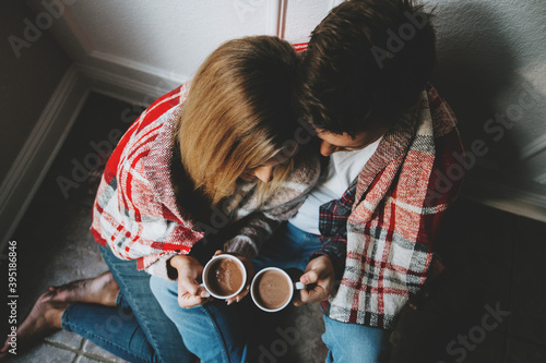 Loving couple snuggled up drinking hot chocolate