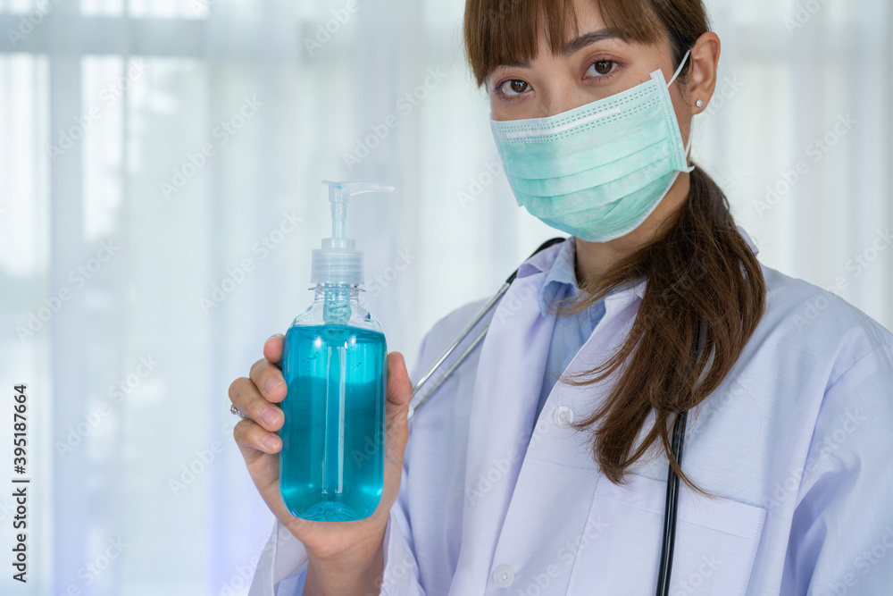 Portrait young Asian doctor woman with gel alcohol for clean hand and protect from covid19 or coronavirus. Female doctor wear white uniform Hand hygiene and antibacterial protection. Portrait young Asian doctor woman with gel alcohol for clean hand and protect from covid19 or coronavirus. Female doctor wear white uniform Hand hygiene and antibacterial protection.