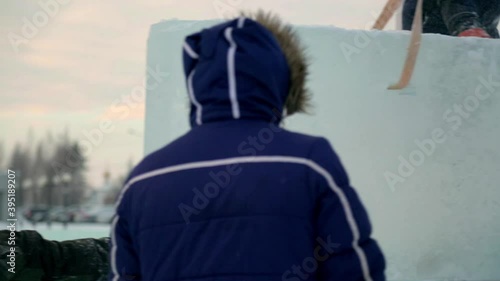 Workers build an ice town from ice blocks for the Christmas holidays